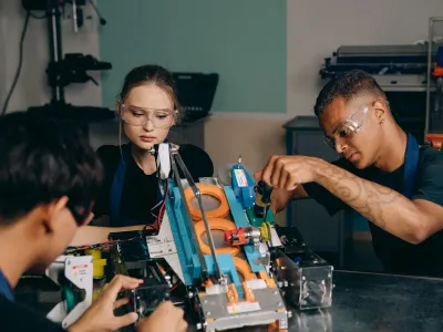 Two adult learners working at a technical training bench