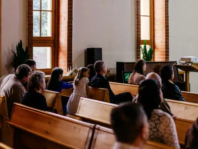 Families seated in church pews during a service