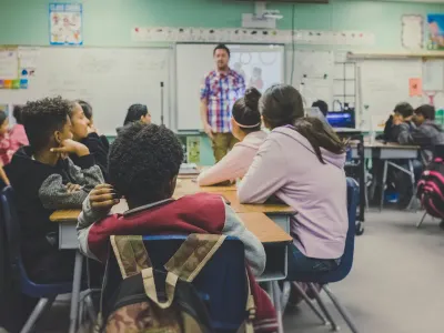 A teacher at the front of a school classroom
