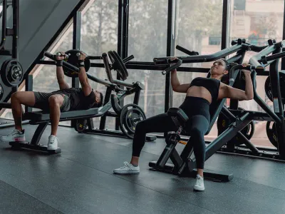 Two members training on machines at a gym